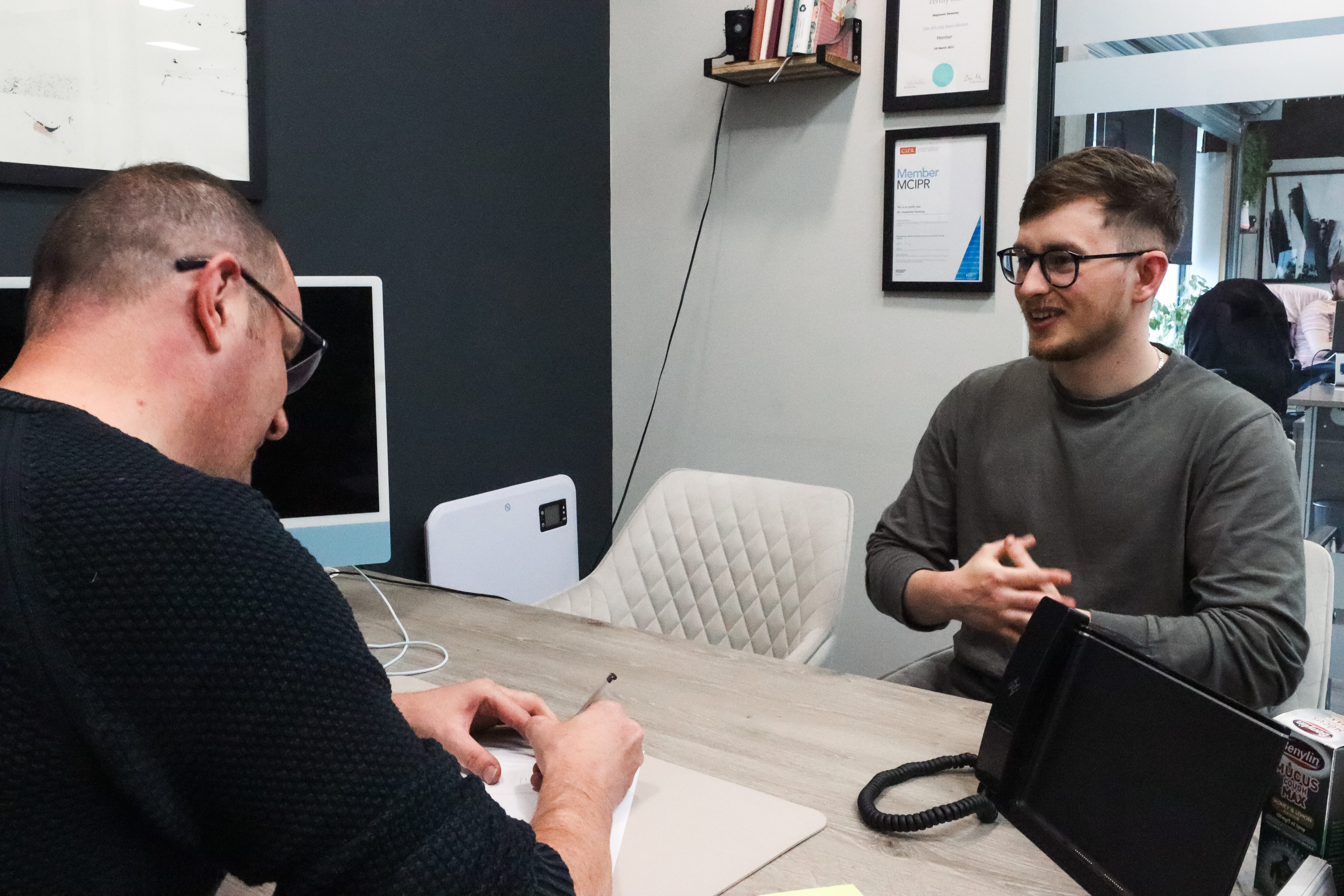 Gary Sweeney and Alex Whitehouse, sitting at desk, discussing ideas