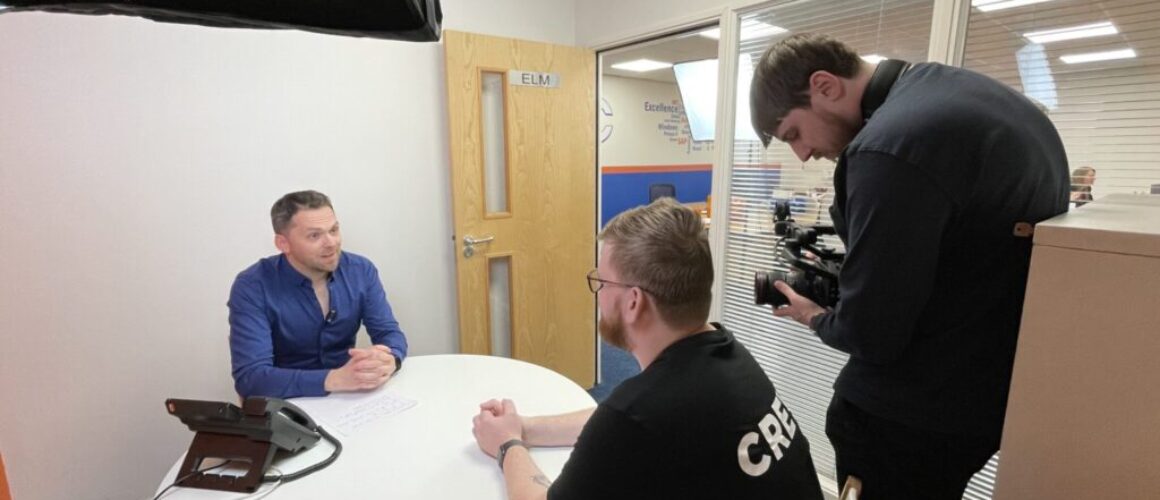 Dale Swann interviewing an OCC staff member while Anthony Trantum operates a camera.